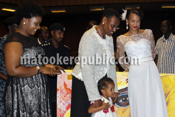 Mrs Museveni with Daniela's baby as Daniela looks on.