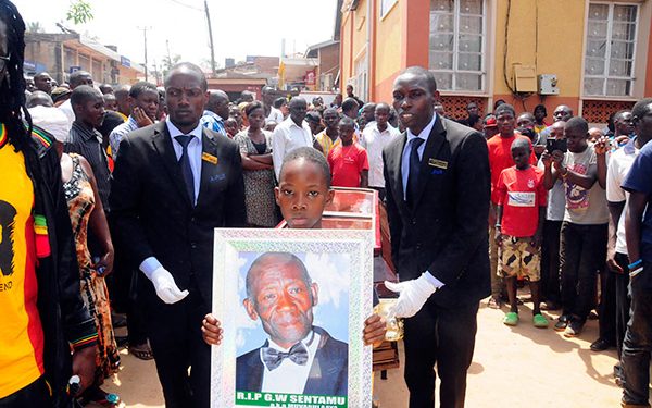 Bobi Wine's son Solomon Kampala leads the funeral procession with a portrait of his late grand father.