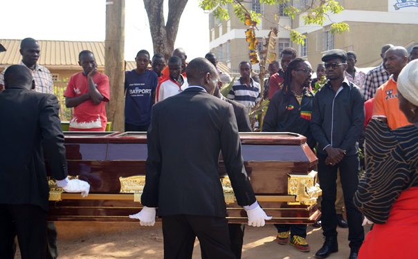 Bobi looks on as Uganda Uganda Funera; Services carries the casket containing the remains of his dad.