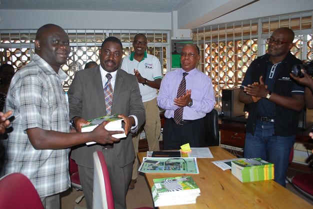 Dr Andrew Seguya ED Uganda Wild life Authority hands over books to Mr Wilson Adriko Librarian MUST as Dean of students Emmanuel Kyagaba and Mr Charly.