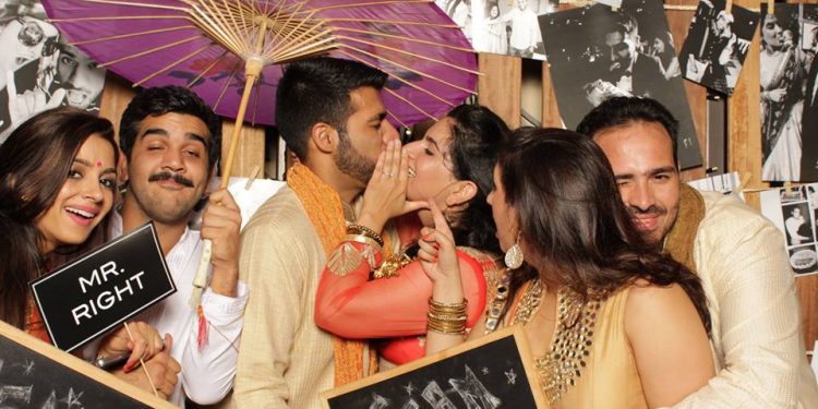 Sheena and Raj Sakaria steal a kiss in this familt portrait.