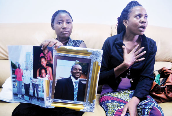 The Late Ngobi's wife (R) and her sister, with a portrait of her husband who was executed in China. 