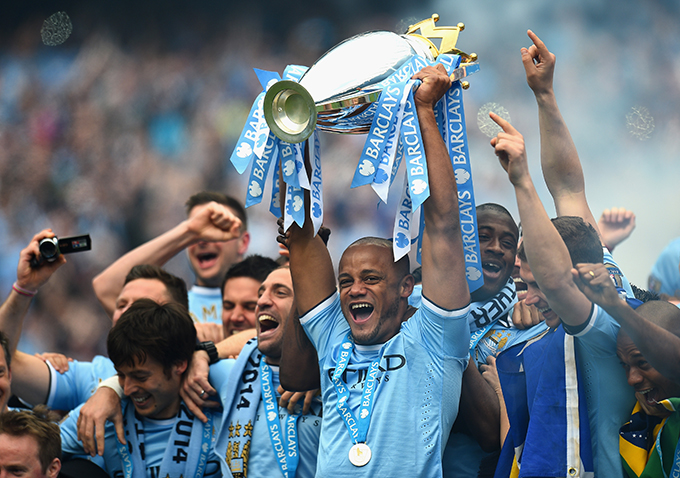 MANCHESTER, ENGLAND - MAY 11:  Vincent Kompany of Manchester City lifts the Premier League trophy at the end of the Barclays Premier League match between Manchester City and West Ham United at the Etihad Stadium on May 11, 2014 in Manchester, England.  (Photo by Shaun Botterill/Getty Images)