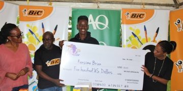 Brian Kansiime with a dummy cheque presented to him.