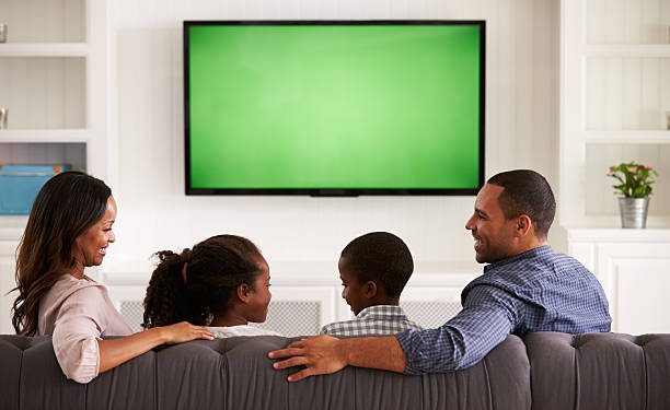 Parents and children watching TV, looking at each other