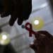 FILE PHOTO: A nurse (L) hands out a red ribbon to a woman, to mark World Aids Day, at the entrance of Emilio Ribas Hospital, in Sao Paulo December 1, 2014. REUTERS/Nacho Doce