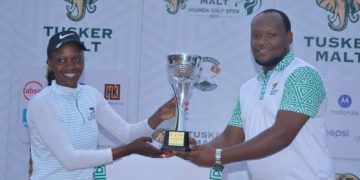 Mark Ethan Kamanyire, Key Accounts Manager UBL hands over the winning trophy to Martha Babirye, the three time title holder of the Tusker Malt Uganda Ladies Open at the Lake Victoria Serena Golf and Spa, Kigo.