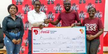 Coca-cola Beverages Uganda's Public Affairs, Communications and Sustainability Director, Kirunda Magoola (2nd left) hands over a dummy cheque worth shs 20 million to the founder and chief executive officer of Boundless Minds, Benjamin Rukwengye  (2nd left). This was during the launch of the 2023 youth mentorship programme at CCBU head office in Namanve.