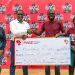 Coca-cola Beverages Uganda's Public Affairs, Communications and Sustainability Director, Kirunda Magoola (2nd left) hands over a dummy cheque worth shs 20 million to the founder and chief executive officer of Boundless Minds, Benjamin Rukwengye  (2nd left). This was during the launch of the 2023 youth mentorship programme at CCBU head office in Namanve.