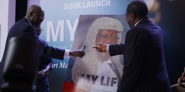 Former Chief Justice Bart Katureebe together with the Chief Guest Amos Wako, Former Attorney General of Kenya unveil his book titled “My Life” during the official book launch at Kampala Serena Hotel yesterday.