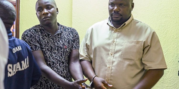 Mubarak Munyagwa and his co-accused stand together in court.