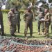 UPDF officers led by Maj Gen Olum displaying a catchment of the weaponry and equipment captured from the ADF.