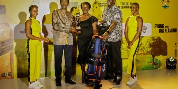 Peace Kabasweka (centre) winner of the Johnnie Walker Uganda Golf Ladies Open Tournament receives her Winner’s package handed over by Uganda Breweries Ltd Managing Director Andrew Kilonzo (R) and Guest of Honour, Security Minister Gen. Jim Muhwezi (L) at the prize giving ceremony.