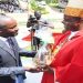 Deputy Speaker Thomas Tayebwa (L) hands over offertory to Lambert Bainomugisha, the Mbarara Archbishop.