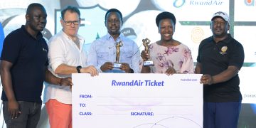 I&M Bank CEO, Robin Bairstow (in white shirt) handing over air tickets to the general winners Peace Kabasweke and Perez Muhwezi.