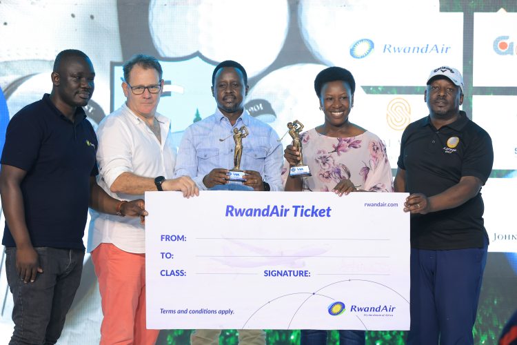 I&M Bank CEO, Robin Bairstow (in white shirt) handing over air tickets to the general winners Peace Kabasweke and Perez Muhwezi.
