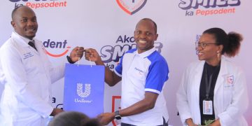 Antony Esyalai, Managing Director at Unilever Uganda hands over a Unilever hamper to Mengo Hospital's Executive Director, Dr Simon Peter Nsingo during the launch of the ‘Ako Ka Smile Ka Pepsodent’ campaign at Mengo this afternoon.