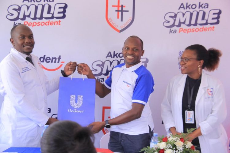 Antony Esyalai, Managing Director at Unilever Uganda hands over a Unilever hamper to Mengo Hospital's Executive Director, Dr Simon Peter Nsingo during the launch of the ‘Ako Ka Smile Ka Pepsodent’ campaign at Mengo this afternoon.