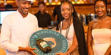 Catherine Ndungu, Marketing and Innovations Director at UBL, presents Chef Angelo with the desirable title of Singleton Culinary Champion as Christine Kyokunda, Brand Manager for Scotch and Reserve, looks on.