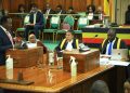 Hon. Wilson Kajwengye (L) speaking during the sitting on Tuesday. Speaker Anita Among (C) and a staff member of Parliament (R) are at the Clerk’s Table.