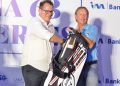 Dave Plenderleith (right) receives a golf bag from I&M Bank CEO Robin Bairstow.