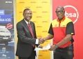 Musa Jallow, Retail and Business Banking Director, Absa Bank Uganda exchanges hands with Joseph Odole, Country Manager, DHL Uganda after the launch.