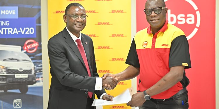 Musa Jallow, Retail and Business Banking Director, Absa Bank Uganda exchanges hands with Joseph Odole, Country Manager, DHL Uganda after the launch.