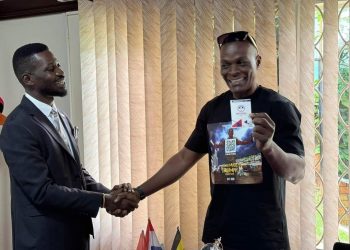 Viboyo receiving his NUP party membership card from Bobi Wine.