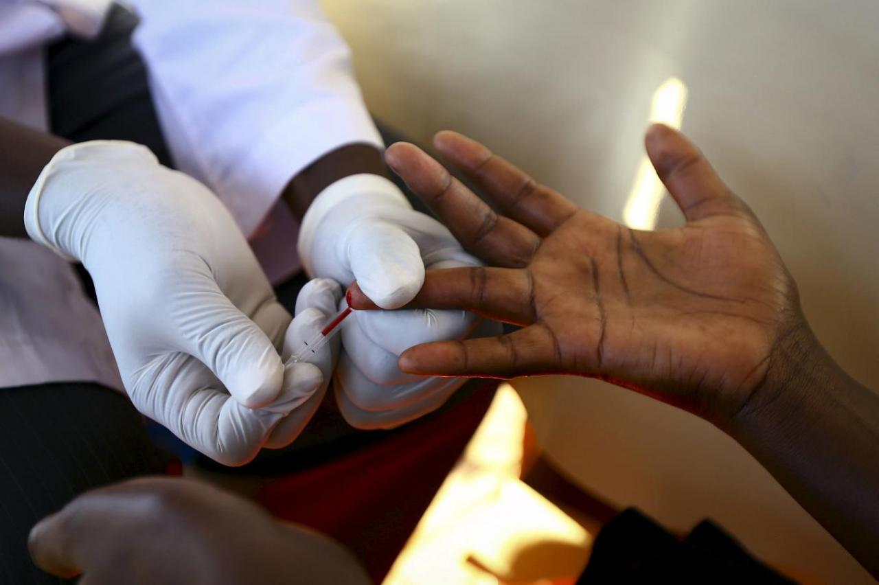 A doctor draws blood from a man to check for HIV/AIDS at a mobile testing unit in Ndeeba, a suburb in Uganda's capital Kampala, in this May 16, 2014 file photo.   REUTERS/Edward Echwalu/Files